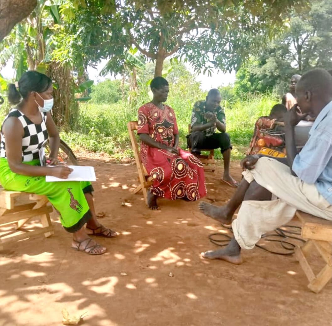 Juliet Esther from DivineAID meets with a local Water Committee, 2022 people gathered in a circle for a meeting